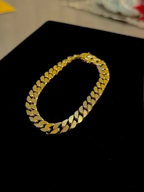 Kundenfoto: massives Panzerarmband aus Gelbgold auf schwarzem Samt