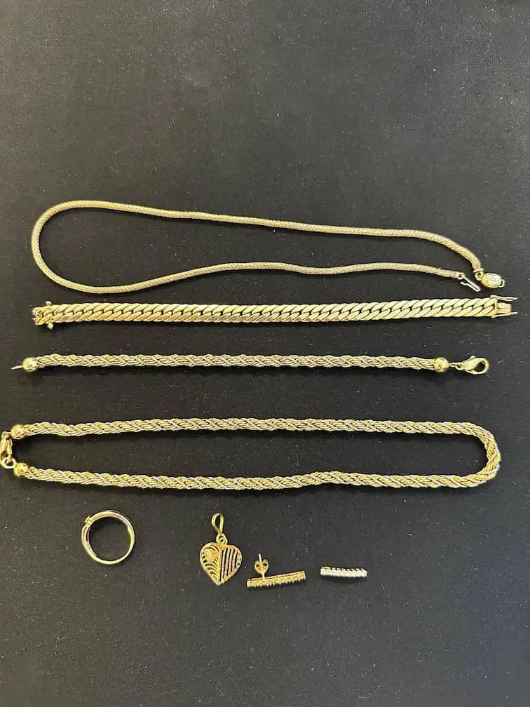 Kundenfoto: Goldketten, Armbänder, Ring, Herzanhänger und Ohrstecker auf schwarzem Samt